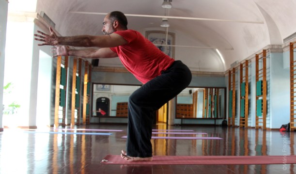 17. Utkatasana Posição da cadeira, pernas fletidas, ancas para trás, braços alinhados pelas orelhas